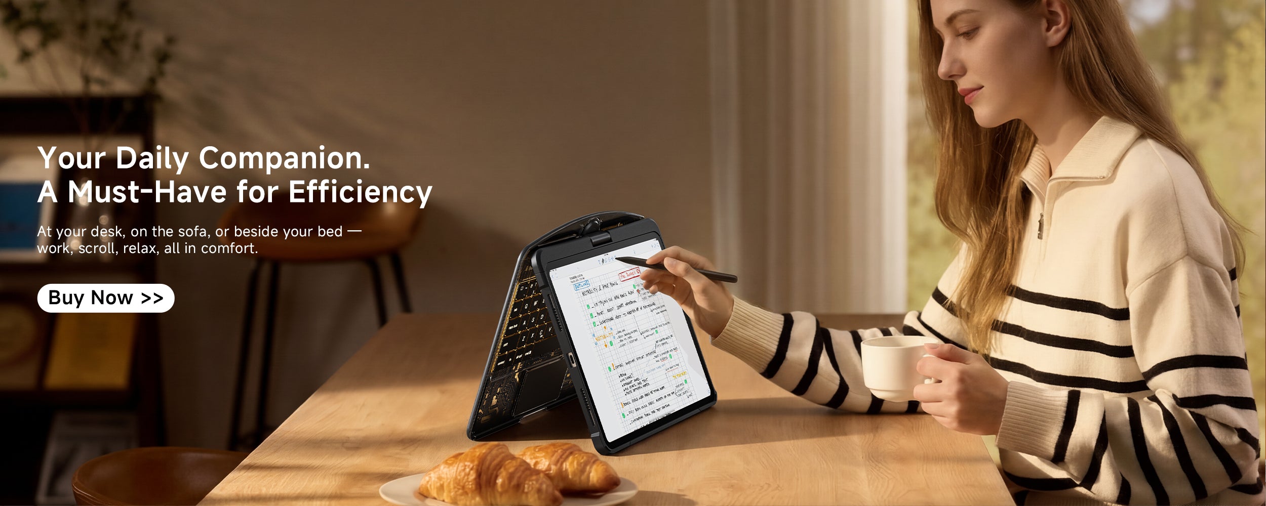 Your Daily Companion – A woman writing on a transparent iPad keyboard case with a pen, enjoying comfort and efficiency while seated with a cup of coffee and pastries in a cozy indoor setting.